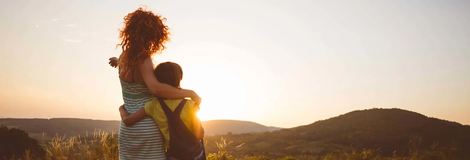 Ragazza e bambino che osservano il paesaggio al tramonto